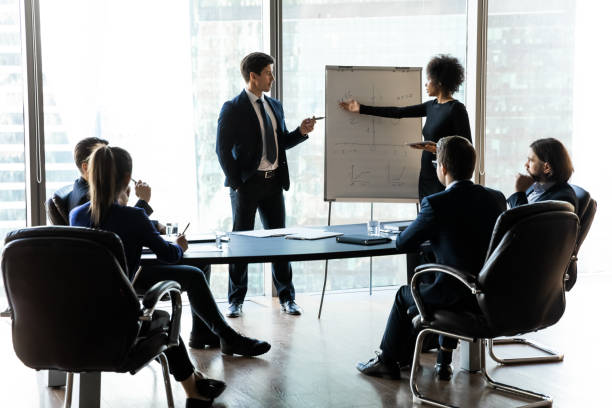 istock Diverse businesspeople present project on whiteboard at meeting 1309380768