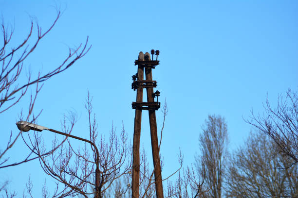 a pair of old wooden poles for carrying electric cables and a blues sky in background
