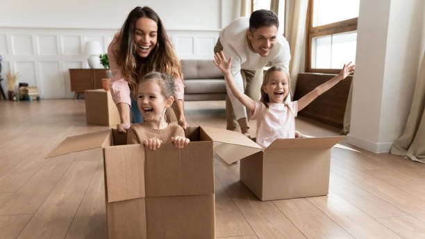 istock Cheerful girls sit inside of boxes during race competition 1309383576