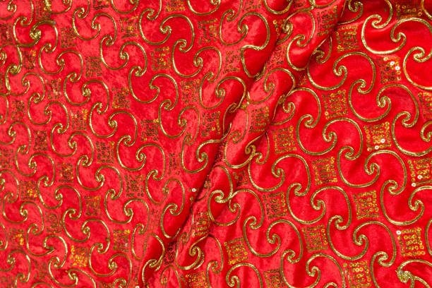 istock Colored red textile satin fabric folded in folds and waves with highlights and texture 1309384752