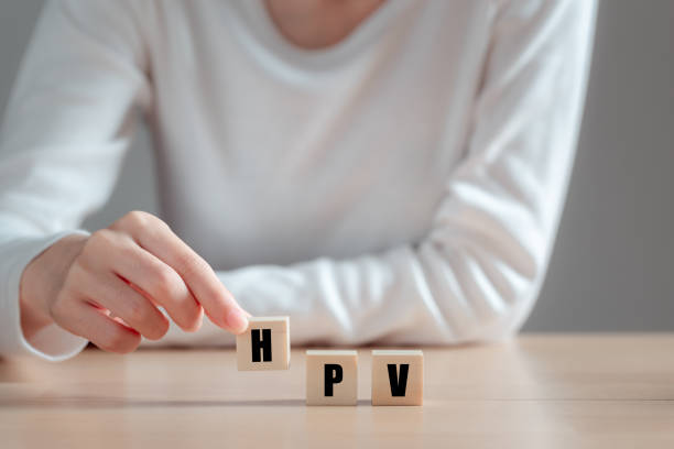 HPV (Human Papillomavirus) acronym on wood block, Asian woman holding wooden block, viruses Some strains infect genitals and can cause cervical cancer. Women health concept. HPV (Human Papillomavirus) acronym on wood block, Asian woman holding wooden block, viruses Some strains infect genitals and can cause cervical cancer. Women health concept. human papilloma virus photos stock pictures, royalty-free photos & images