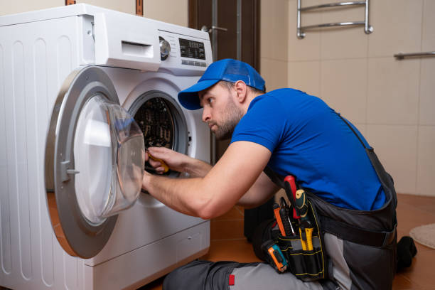 arbeiter klempner repariert eine waschmaschine zu hause. installation oder reparatur von waschmaschinen. klempner-verbindungsgerät - waschmaschine stock-fotos und bilder