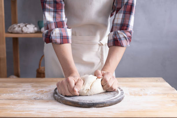 istock Baker man kneading or making dough and bakery ingredients for homemade bread cooking on shelf. Bakery concept 1309386234
