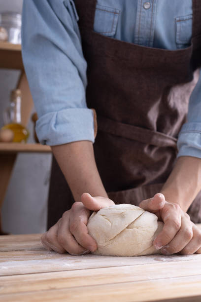 istock Baker man kneading or making dough and bakery ingredients for homemade bread cooking on shelf. Bakery concept 1309386262