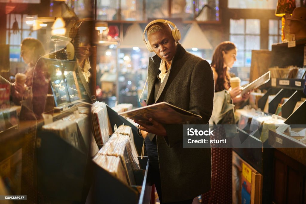 browsing records in a vintage shop Record - Analog Audio Stock Photo