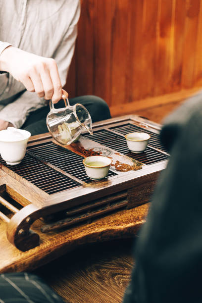 istock Chinese tea ceremony, a man pours tea into cups on a bamboo table chaban 1309389173