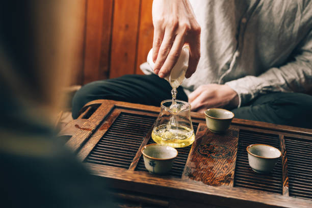 istock Chinese tea ceremony, a man pours tea into cups on a bamboo table chaban 1309394460
