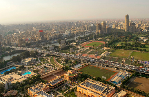 Cairo-Egypt - October 04, 2020: Beautiful city overview from Cairo Tower and heavy car traffic on a highway. Panorama of Cairo cityscape with Nile river. Al Zamaler - Omar Al Khayam