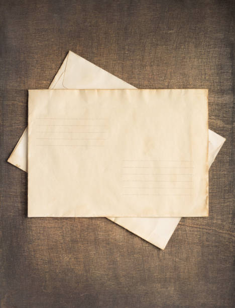 istock Old cardboard postal envelope at wooden background table board texture. Retro post concept 1309396073