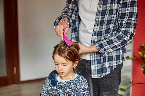 istock Father combing, brushing his daughter's hair at home 1309398118