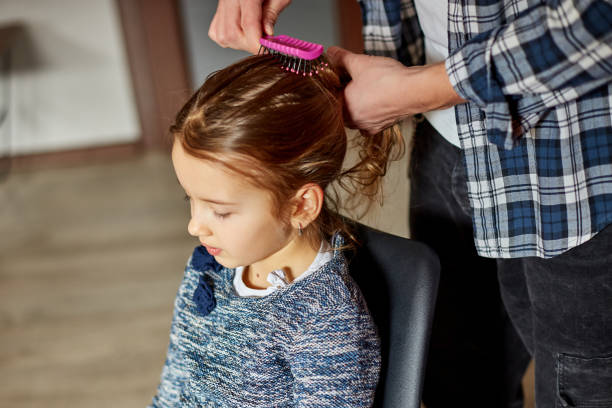 istock Father combing, brushing his daughter's hair at home 1309398122