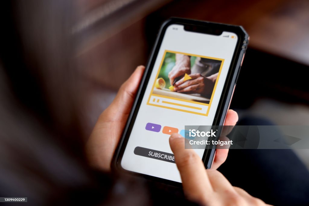 Woman watching vlog on her mobile phone Subscription Stock Photo
