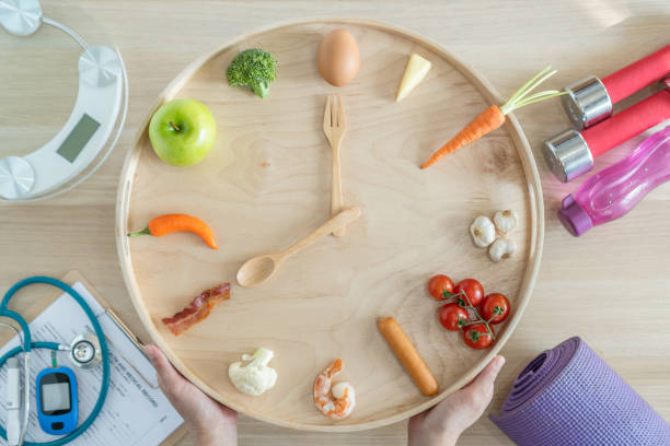 istock Intermittent fasting IF diet concept with 16:8 hour clock timer for skipping meal and eating keto low carb, high fat food meal healthy nutritional dish with gym exercise for body weight loss 1309403364