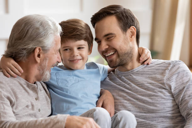 istock Close up happy three generations of men hugging, having fun 1309403931