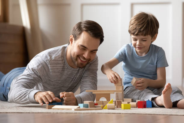 istock Close up happy father playing with adorable son on floor 1309403947