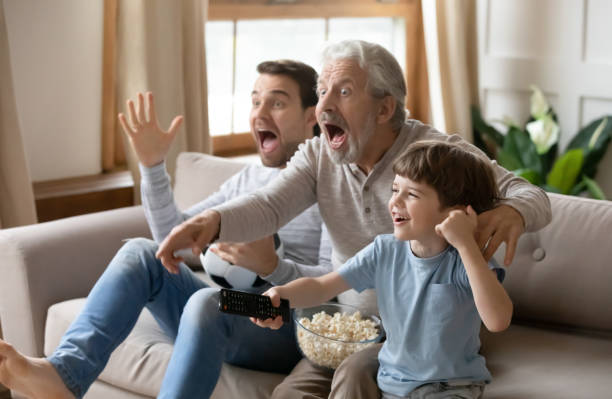 istock Overjoyed little boy with father and grandfather supporting favorite team 1309403975