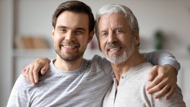 istock Head shot portrait smiling young man with mature father hugging 1309404064