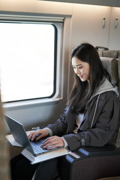 istock Asian girl using laptop on the train 1309407008