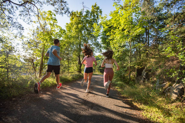 istock Three young people jogging together in nature. 1309407285
