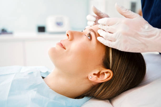 cosmetologist preparing patient for facial treatments - exfoliating scrub imagens e fotografias de stock