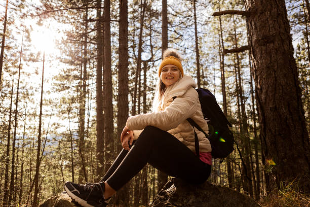 istock Young woman in woods hiking alone ,taking a break smiling 1309408297