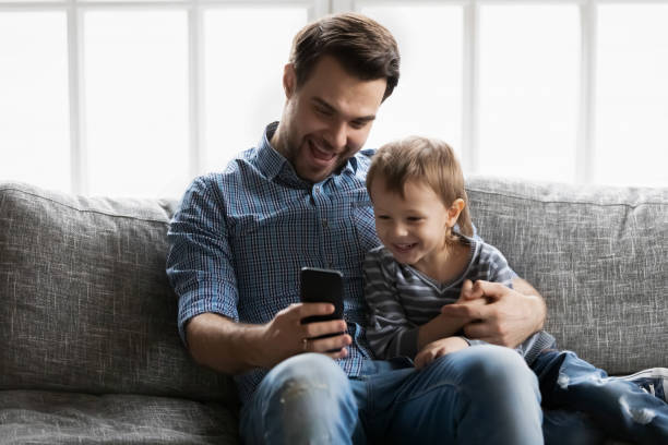 istock Happy daddy and cute son kid relaxing on sofa 1309409474