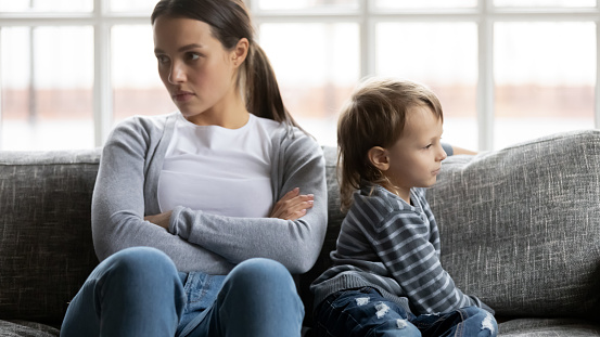 Angry strict mum and son going through conflict, kids bad discipline and behavior problem, feeling stress. Quiet upset mother and child expressing ignore, feud and disagreement, thinking over quarrel