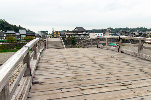 Iwakuni, Yamaguchi, JAPAN - Sep 24 2020 : Cityscape from the Kintai Bridge (Kintaikyo), a historical wooden arch bridge in Iwakuni, in cloudy day. It was built in 1673, spanning the Nishiki River