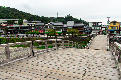 Iwakuni, Yamaguchi, JAPAN - Sep 24 2020 : Cityscape from the Kintai Bridge (Kintaikyo), a historical wooden arch bridge in Iwakuni, in cloudy day. It was built in 1673, spanning the Nishiki River