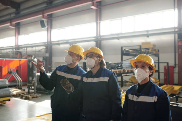 istock Group of workers or engineers looking at new industrial machine in workshop and discussing it 1309413047