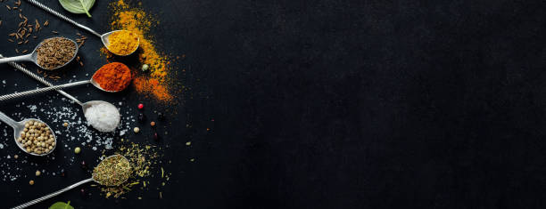 istock Tasty colorful spices in spoons on dark background. 1309414092