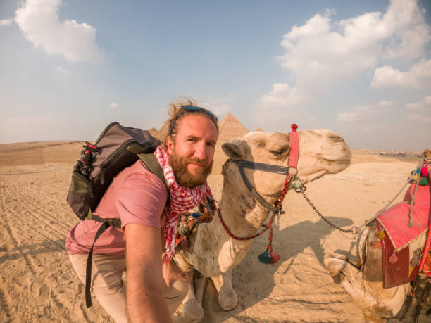 istock Man takes selfie with camel at the pyramids in Egypt 1309416490