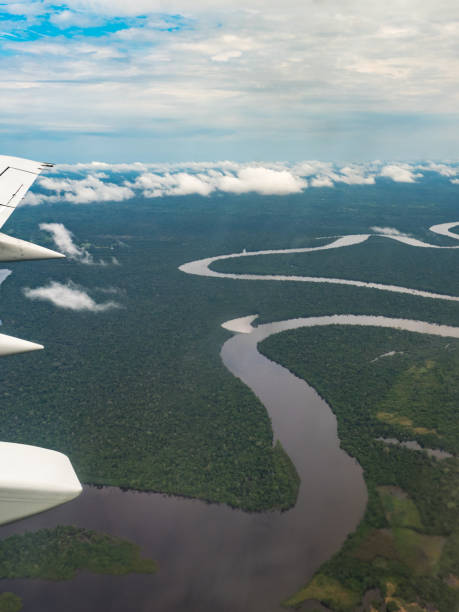 Over Amazon River View from airplane window. Wing of an airplane flying above the clouds over Amazon River. Top View of Amazon rainforest. Peru, Brazil. Colombia. amazon forest stock pictures, royalty-free photos & images