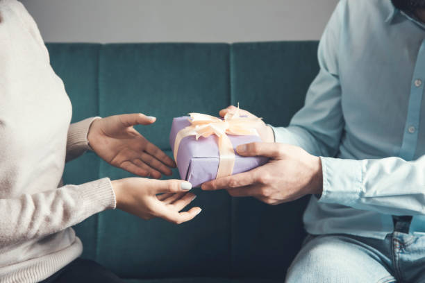 istock young man is giving a present to woman 1309421985