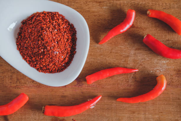 istock Chili powder and fresh peppers on old wood table background. 1309422032