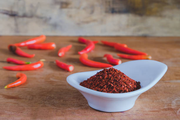 istock Chili powder and fresh peppers on old wood table background. 1309422039