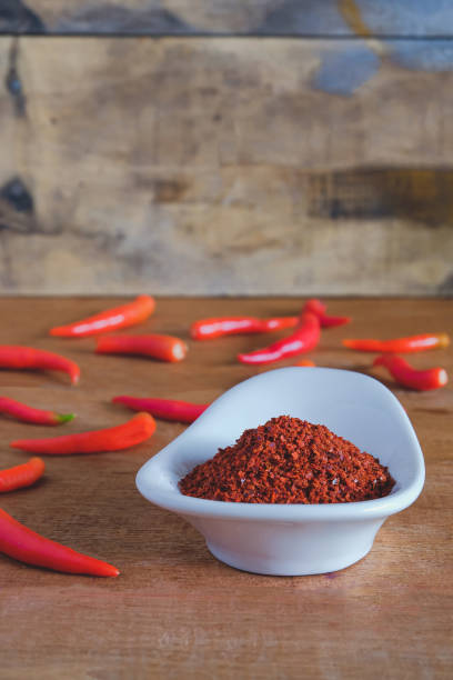 istock Chili powder and fresh peppers on old wood table background. 1309422047