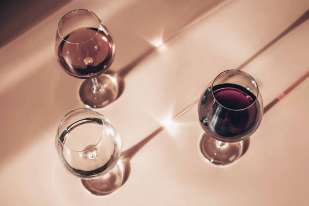 glasses of red, rose and white wine with sunshine shadow effect. concept of wine tasting. flat lay, top view. - champagne pink luxury table imagens e fotografias de stock