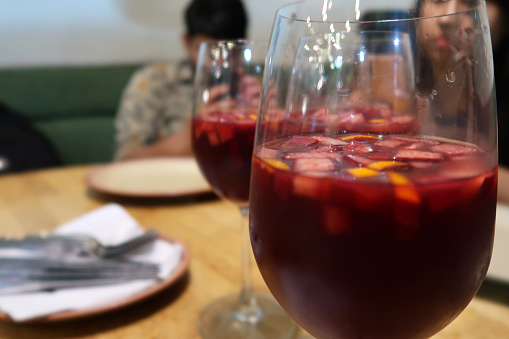 Stock photo showing wine glasses containing Sangria made from red wine, orange juice, brandy, chopped fruit and sugar.