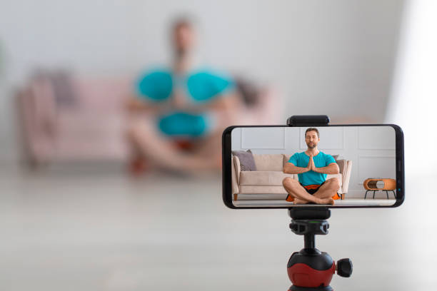 istock Middle aged man online streaming yoga workout. Live streaming on a smartphone. Focus on smartphone 1309424752