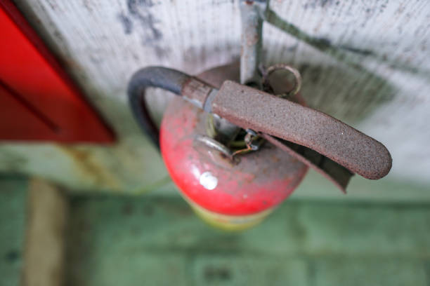 close-up on fire fighting equipment in modern building. old rusty fire extinguisher hangs on the wall.  over look. - office tool flash imagens e fotografias de stock