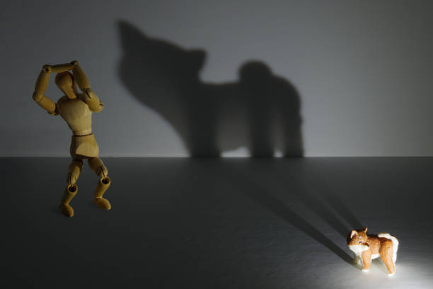 A drawing doll scared by the shadow of a giant beast projected by a puppy stock photo