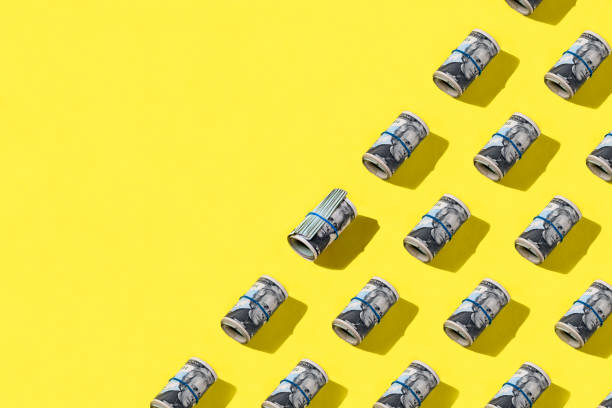 istock Dollar rolls flat lay on yellow background 1309429912