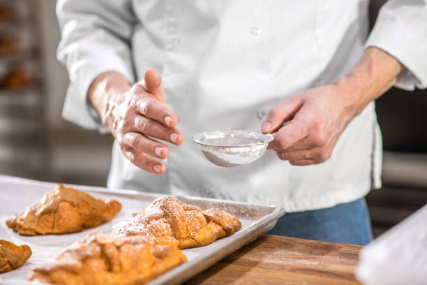 istock Male hands sprinkling confectionery with powdered sugar 1309431239
