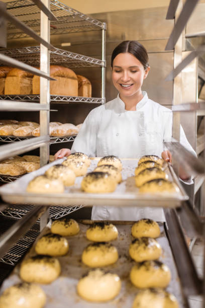 istock Involved woman folding baking trays with buns 1309431264