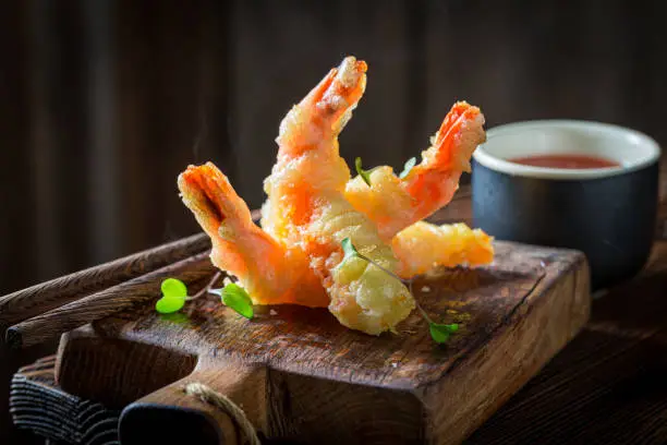 Closeup of shrimp in tempura with red sauce. Old Chinese cuisine.