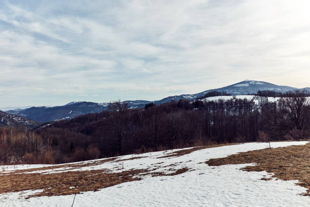 View from a mountain top with some snow on distant hills.