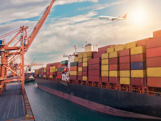 istock Airplane flying over the container port. 1309437477