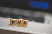 PHP programming web language: Wooden cubes with letters “PHP” lying on a laptop, concept
