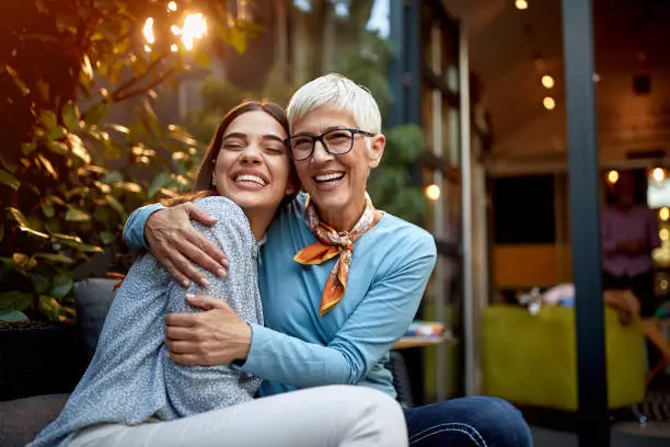 Photo of portrait of a senior mother and adult daughter, hugging, smiling. Love, affection, happiness concept